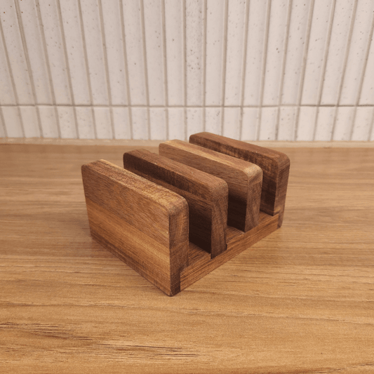 Acacia Board Stand with three slots holding cutting boards upright on wooden surface